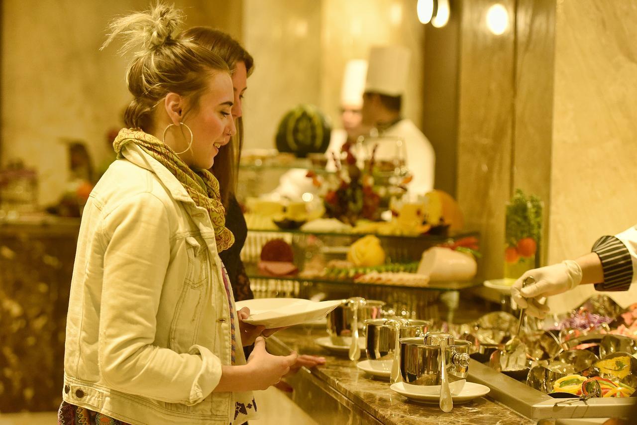 فندق أوشن بلو السخنة عين السخنة المظهر الخارجي الصورة A woman selecting food from a buffet